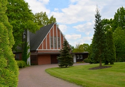 Außenansicht der Kapelle auf dem Südfriedhof Trittau mit Weg und Grünfläche.