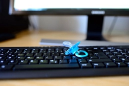 Blauer Schnuller liegt auf einer Computertastatur vor einem Bildschirm.&nbsp;&copy;&nbsp;pixabay.com